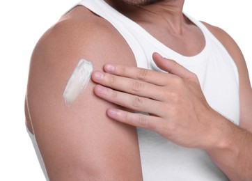 Photo of Man applying sun protection cream onto his shoulder against white background, closeup