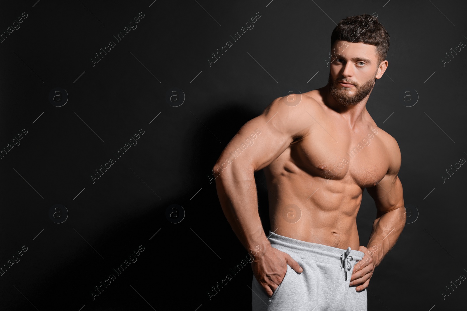 Photo of Handsome muscular man on black background, space for text. Sexy body