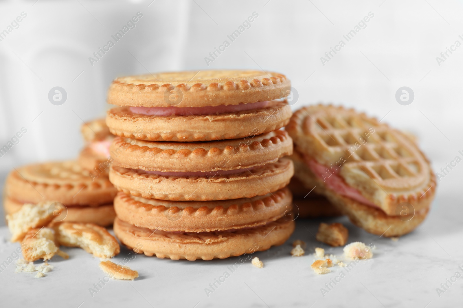 Photo of Tasty sandwich cookies with cream on white marble table, closeup