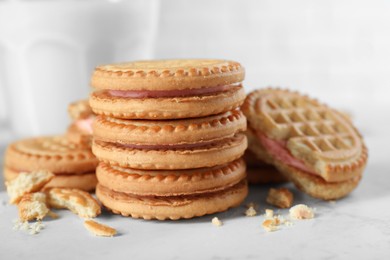 Photo of Tasty sandwich cookies with cream on white marble table, closeup