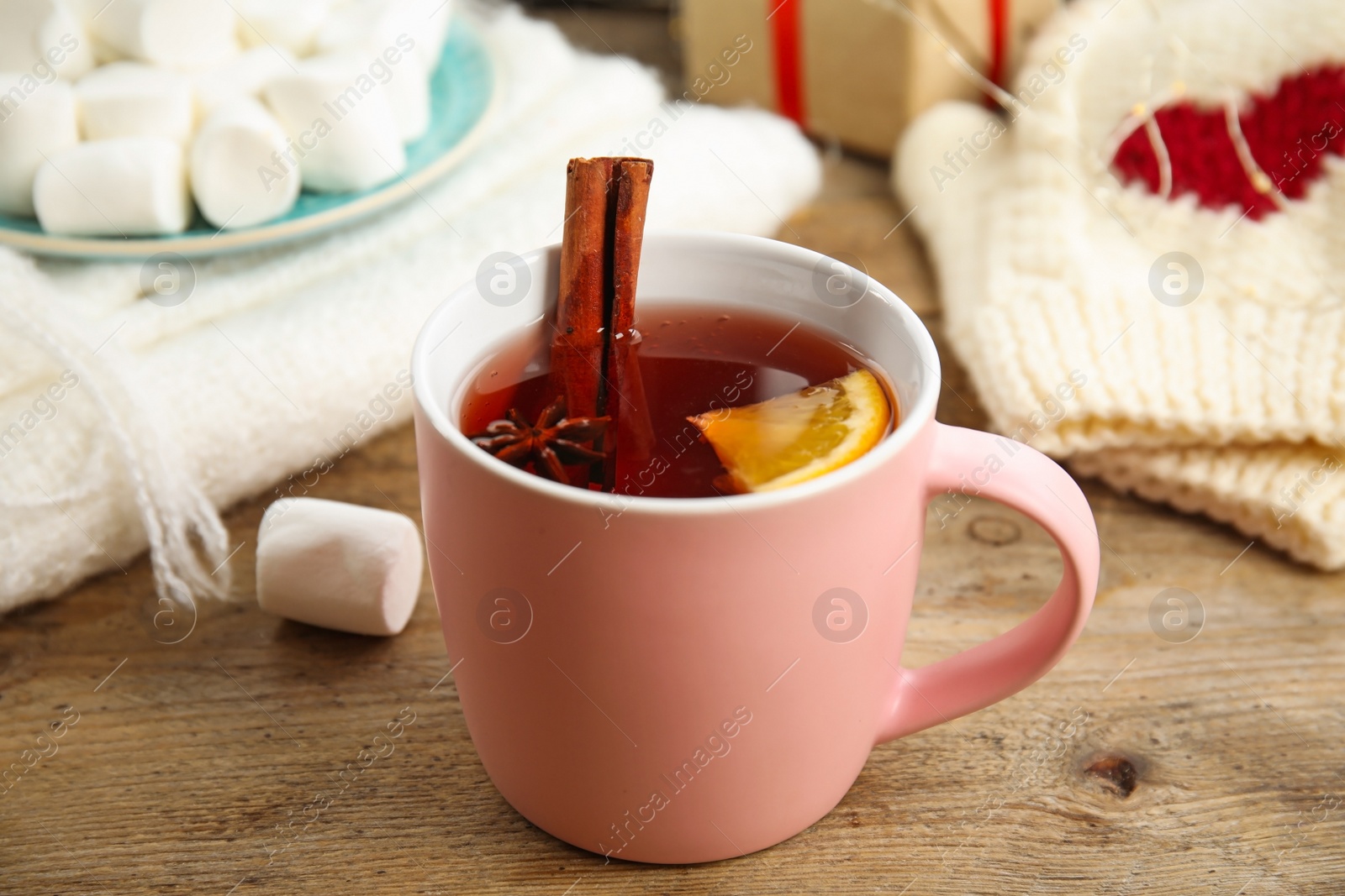 Photo of Cup of hot mulled wine on wooden table. Winter drink