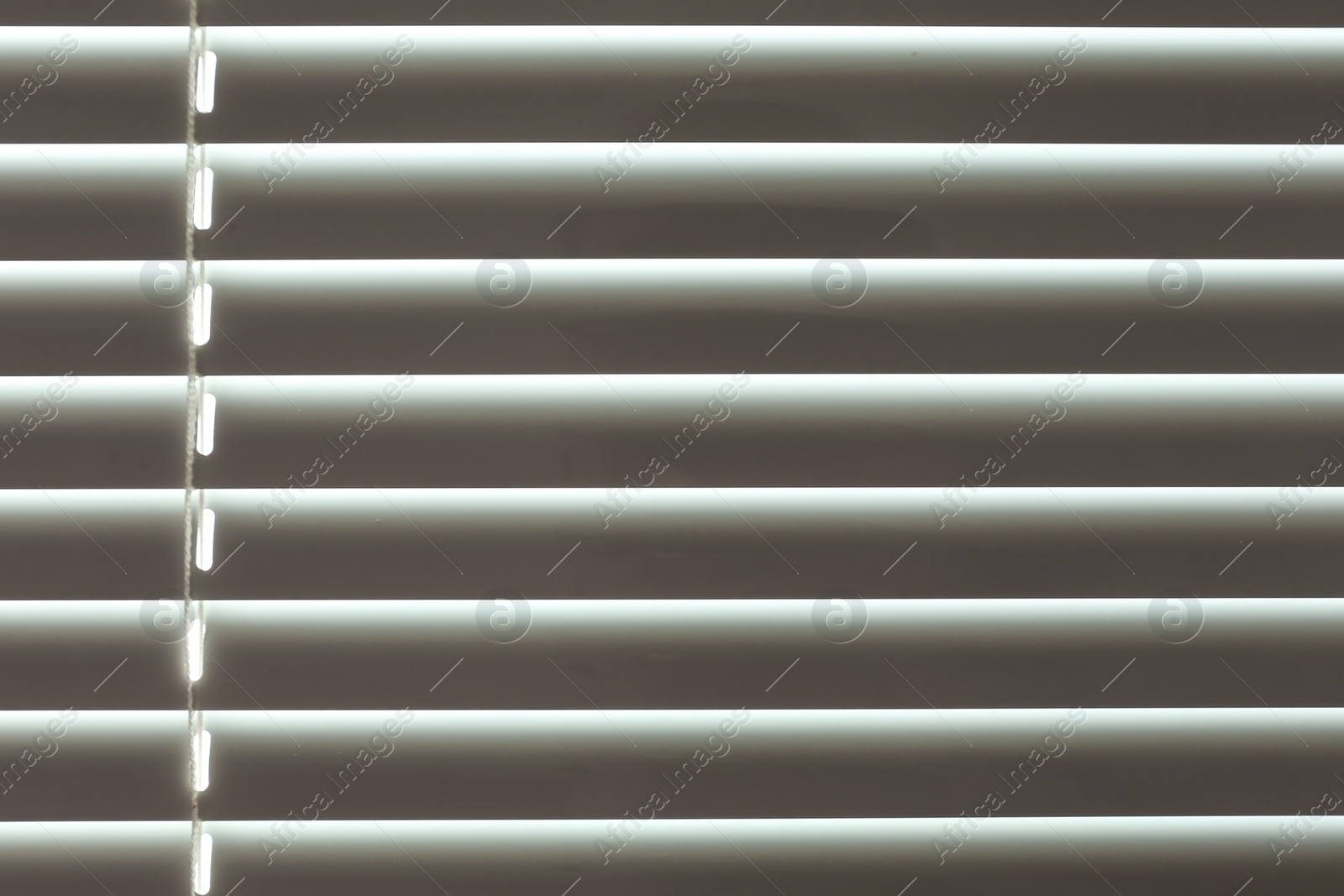 Photo of Closed modern white window blinds as background, closeup view