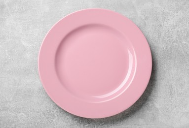 Photo of Empty pink ceramic plate on light grey table, top view