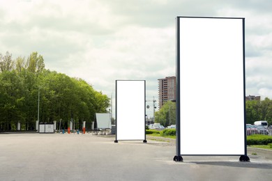 Photo of Blank advertising boards on sidewalk in city. Mockup for design