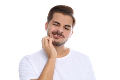 Photo of Young man scratching face on white background. Annoying itch