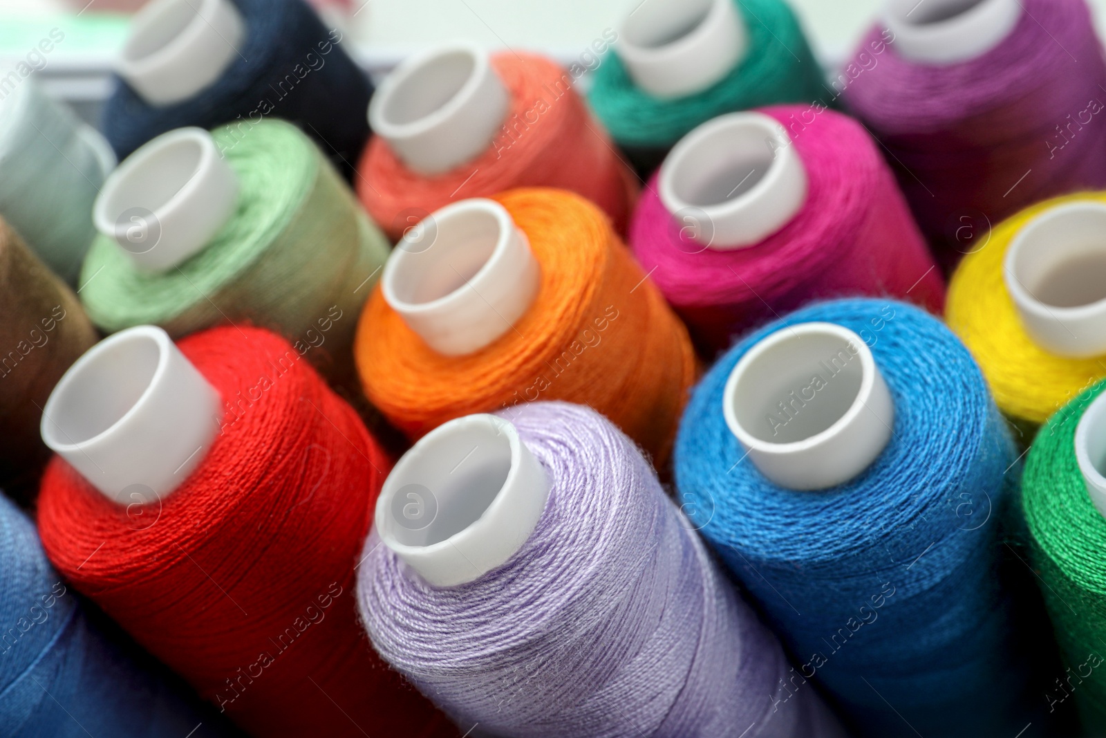 Photo of Closeup view of colorful sewing threads as background