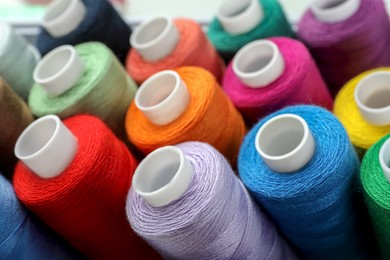 Photo of Closeup view of colorful sewing threads as background