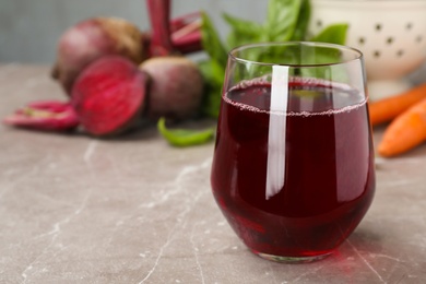 Photo of Glass with fresh beet juice on table