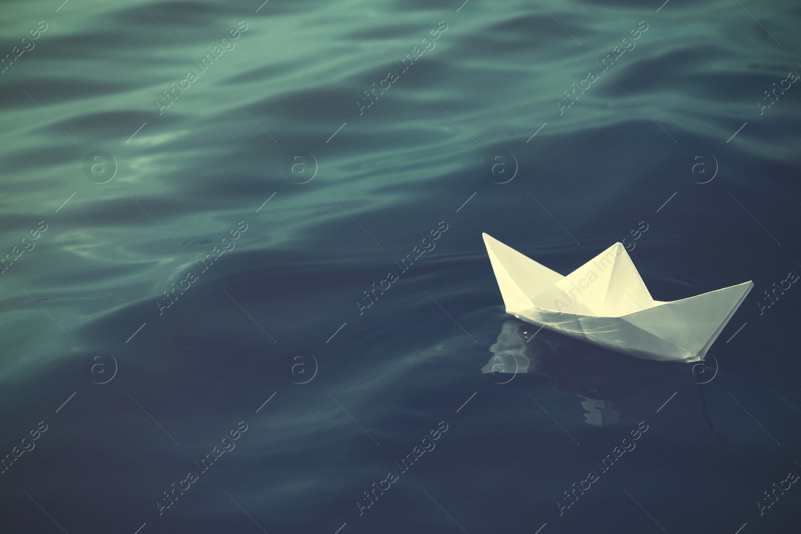 Image of White paper boat floating on river. Retro photo effect