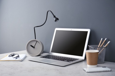 Photo of Modern workplace with laptop on table. Blank screen for mockup