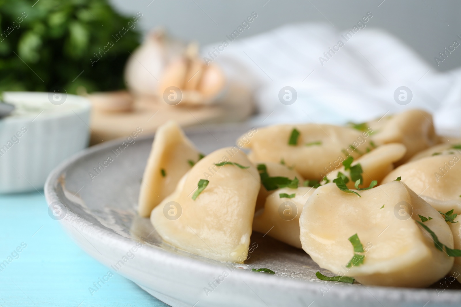 Photo of Delicious cooked dumplings on light blue wooden table, closeup