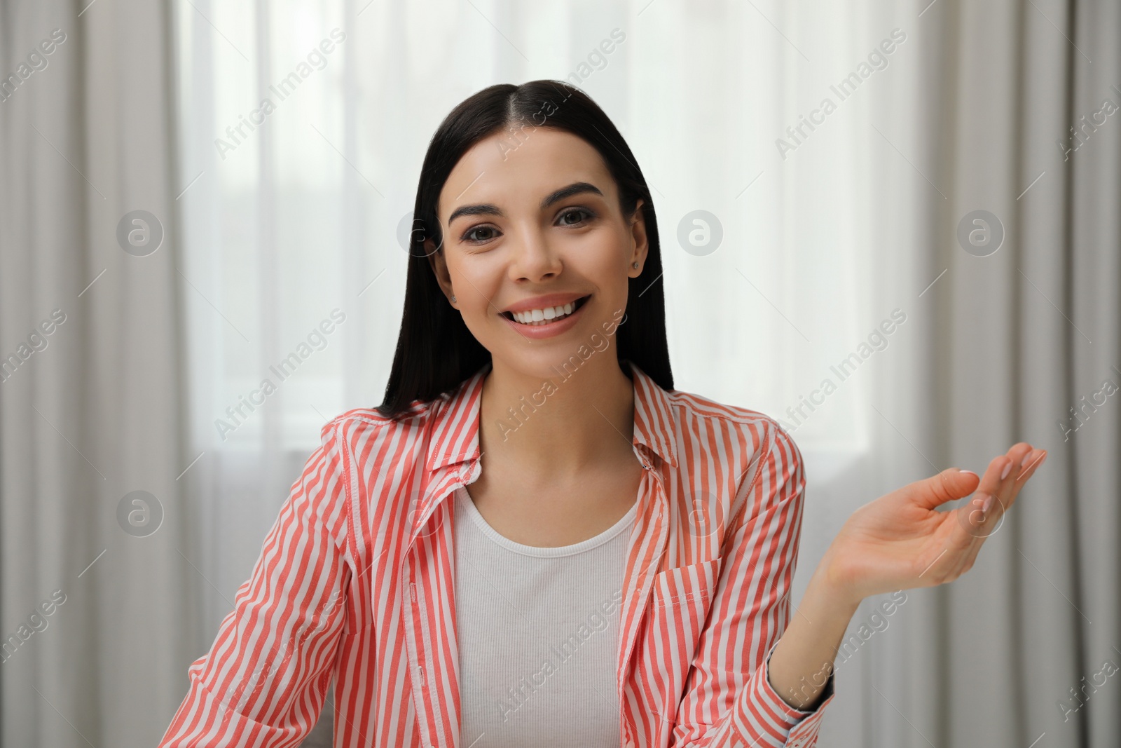 Photo of Beautiful young woman conducting webinar in room, camera view