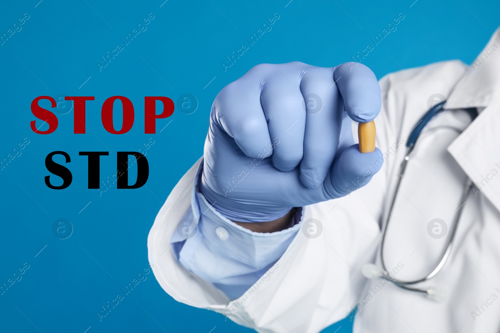 Image of STOP STD. Doctor holding suppository on blue background, closeup