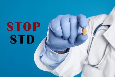 STOP STD. Doctor holding suppository on blue background, closeup