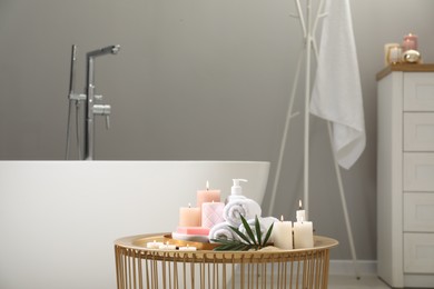 Photo of Stylish bathroom interior with ceramic tub and spa products on table