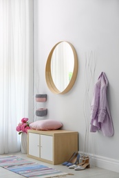 Photo of Stylish hallway interior with round mirror on white wall