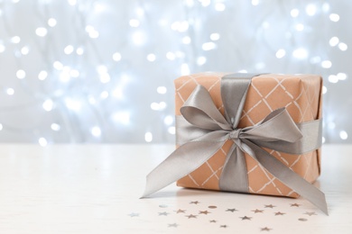 Photo of Christmas gift on table against blurred background