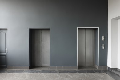 Closed stylish elevator doors in clean hall