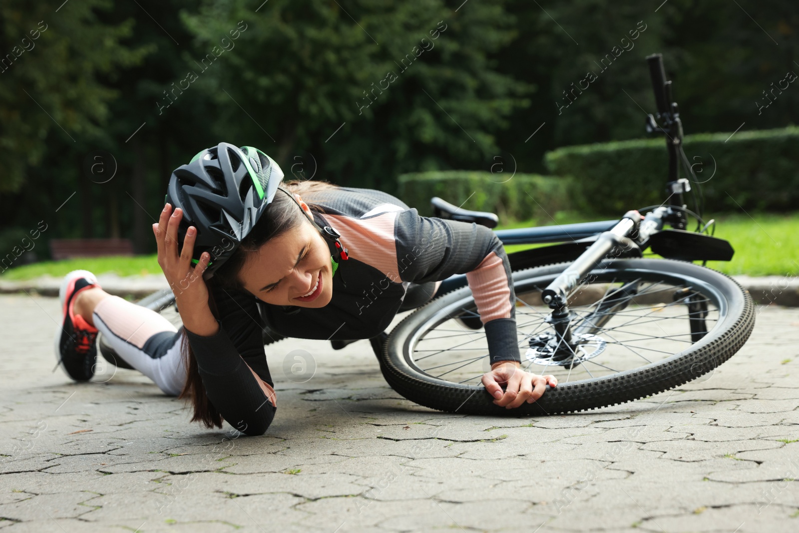 Photo of Young woman fallen off her bicycle in park