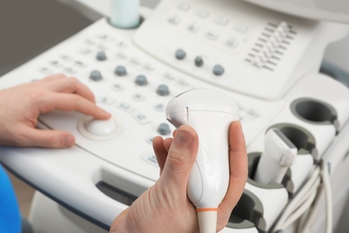 Photo of Professional sonographer using modern ultrasound machine in clinic, closeup