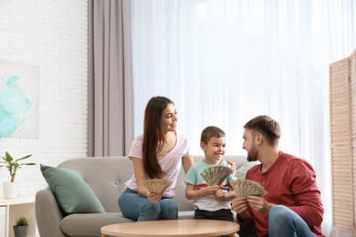 Happy family with money at table indoors