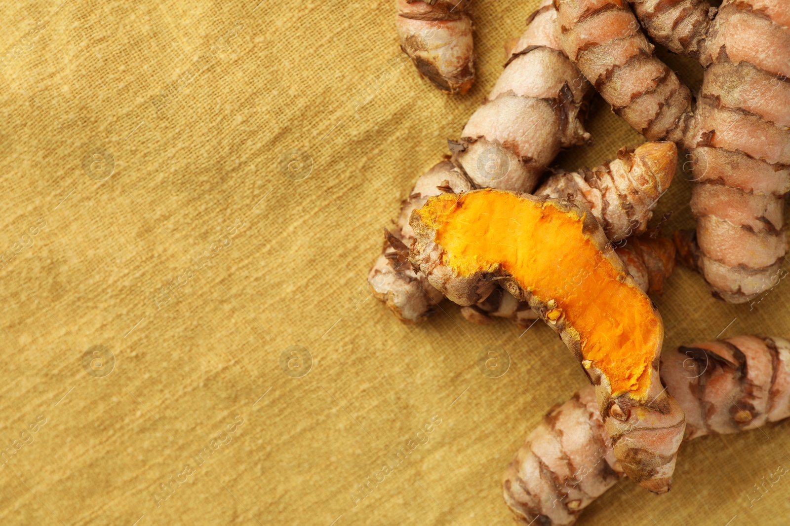 Photo of Many raw turmeric roots on table, flat lay. Space for text