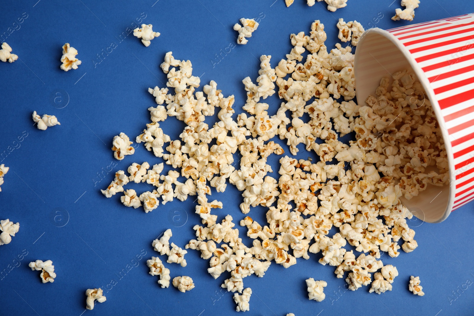 Photo of Tasty pop corn on blue background, flat lay