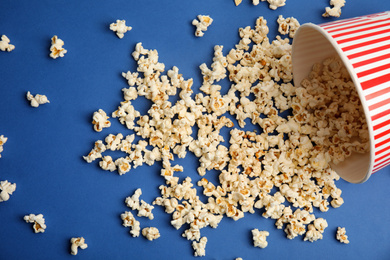 Photo of Tasty pop corn on blue background, flat lay