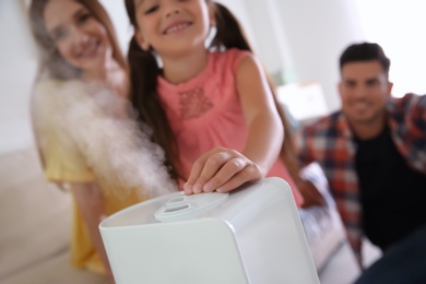 Family near modern air humidifier at home