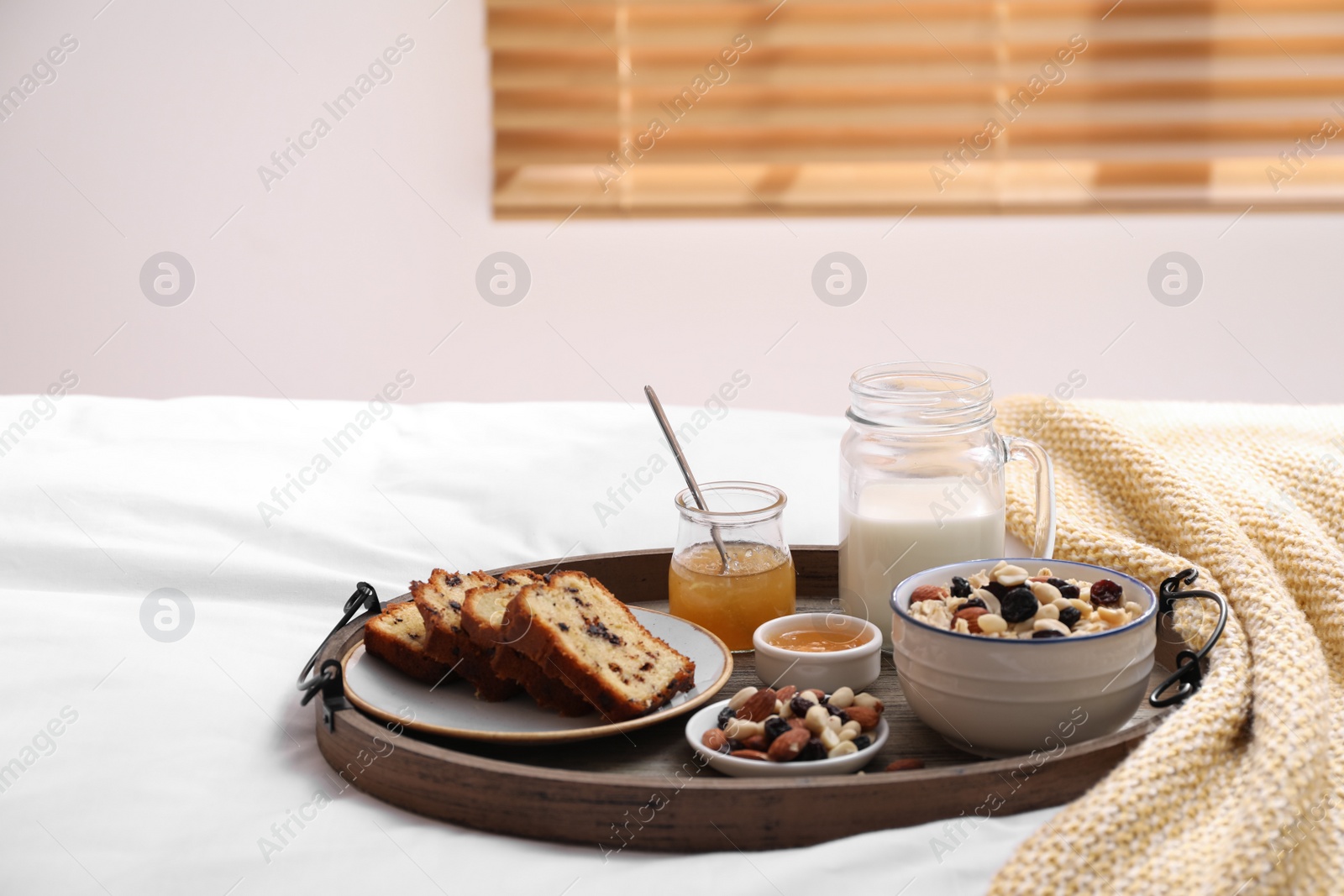 Photo of Tray with tasty breakfast on bed in morning. Space for text