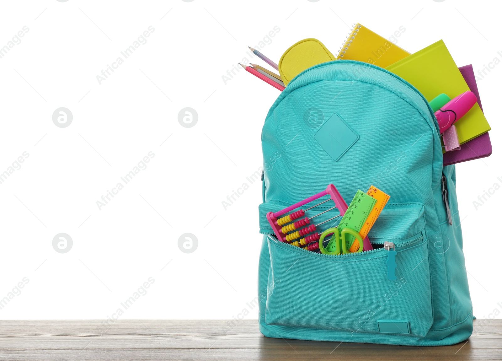 Photo of Stylish backpack with different school stationary on wooden table against white background