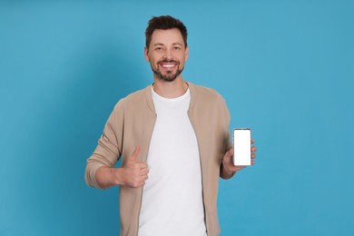 Photo of Happy man with phone on light blue background