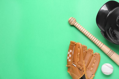 Photo of Baseball glove, bat, ball and batting helmet on green background, flat lay. Space for text