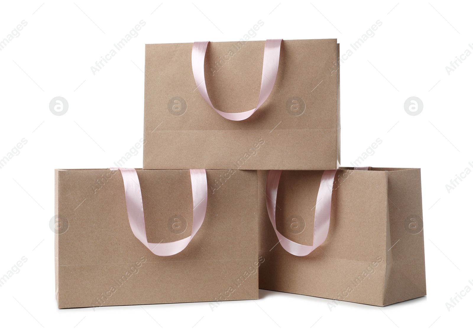 Photo of Paper shopping bags with ribbon handles on white background. Mockup for design