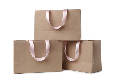 Paper shopping bags with ribbon handles on white background. Mockup for design