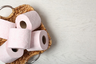 Tray with toilet paper rolls on white wooden background, top view. Space for text