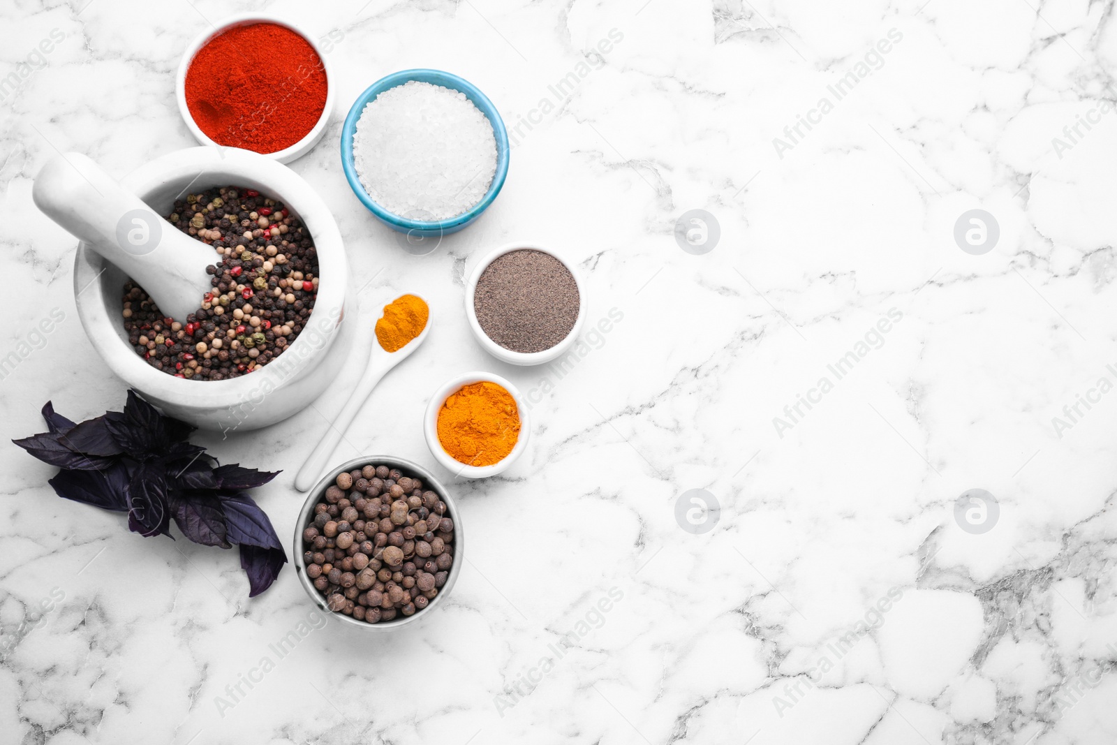 Photo of Flat lay composition with mortar and different spices on white marble table, space for text