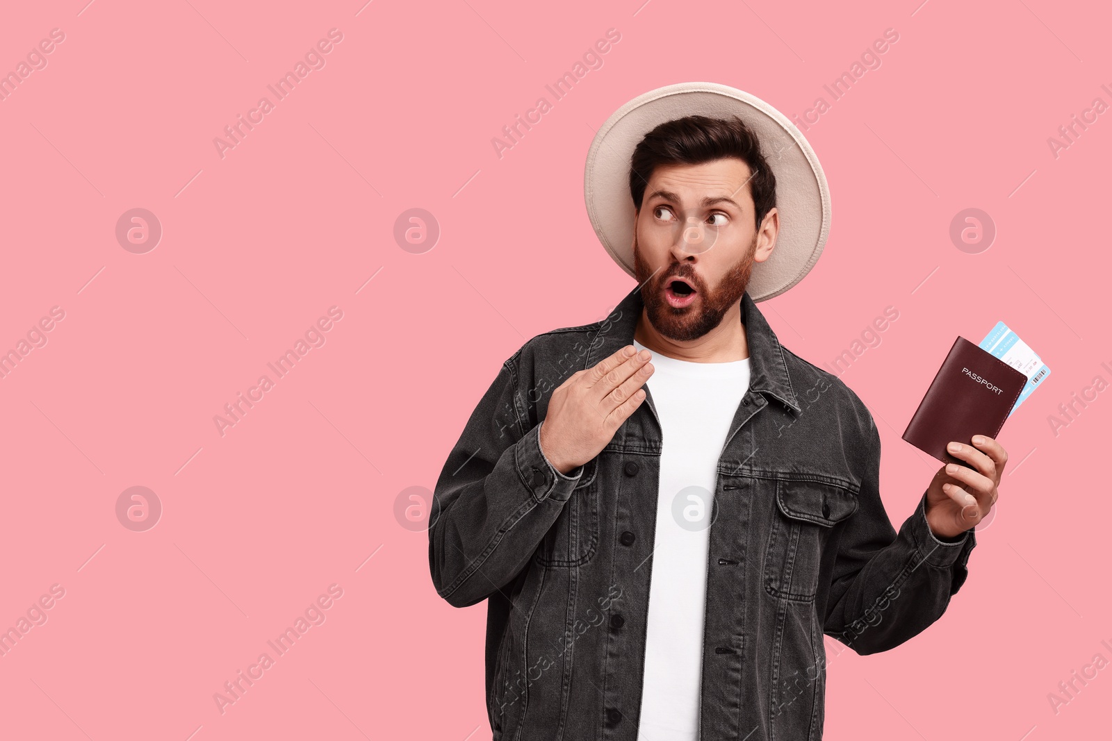 Photo of Surprised man with passport and tickets on pink background. Space for text