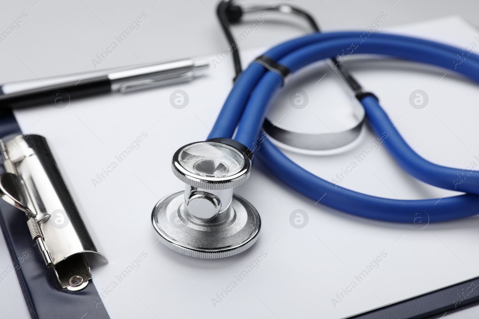 Photo of Stethoscope and clipboard on white background, closeup