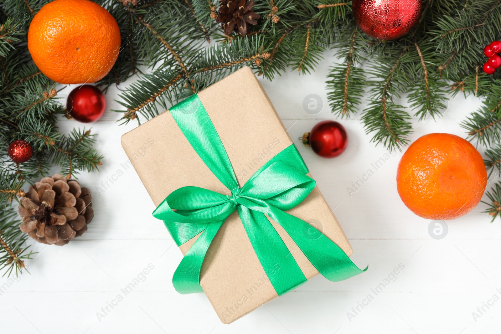 Photo of Flat lay composition with Christmas gift box and decor on white wooden table