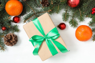 Photo of Flat lay composition with Christmas gift box and decor on white wooden table