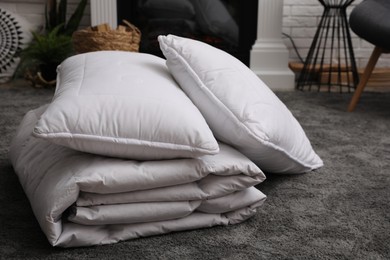 Photo of Soft blanket and pillows on floor indoors
