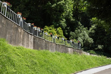 Photo of Picturesque view of stone fence with flowers on sunny day