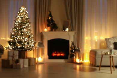 Stylish living room interior with Christmas tree near beautiful fireplace, blurred view