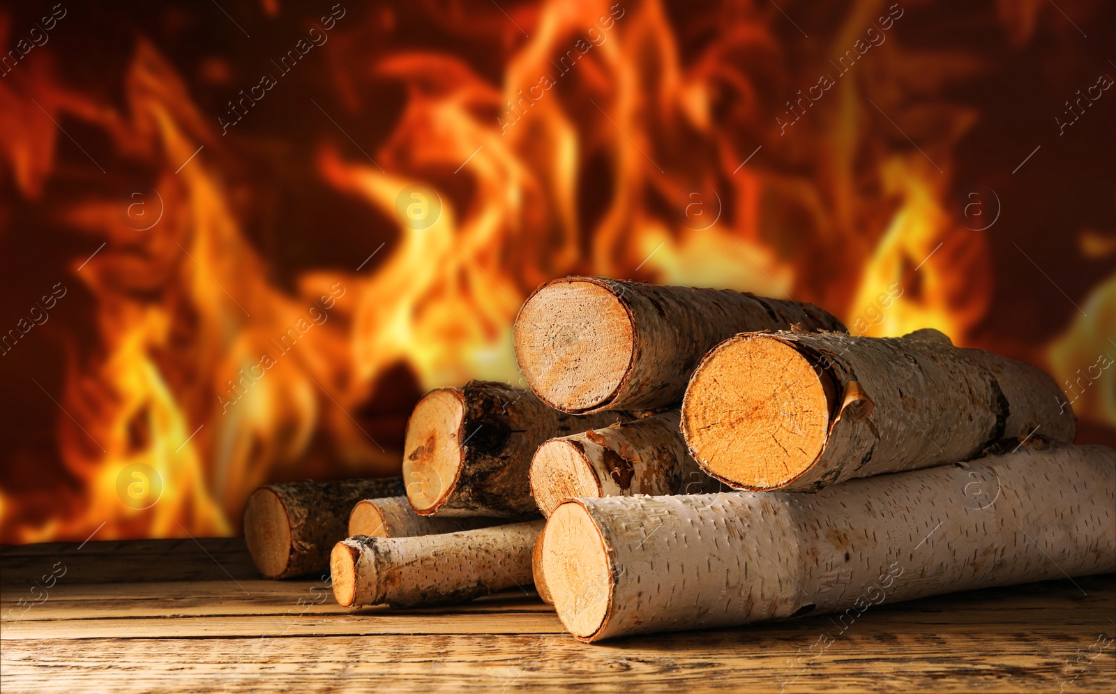 Image of Dry wood and burning fire on background. Cozy atmosphere