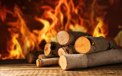 Dry wood and burning fire on background. Cozy atmosphere