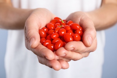 Woman holding fresh goji berries, closeup view