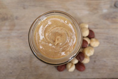 Tasty hazelnut nut paste in jar on table, top view