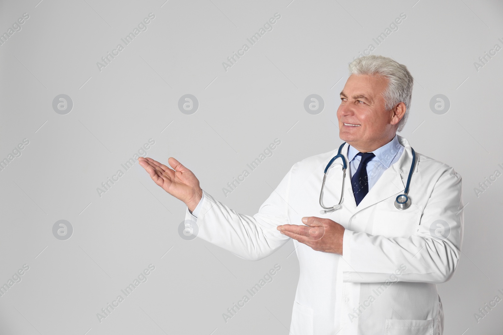 Photo of Portrait of senior doctor against light background