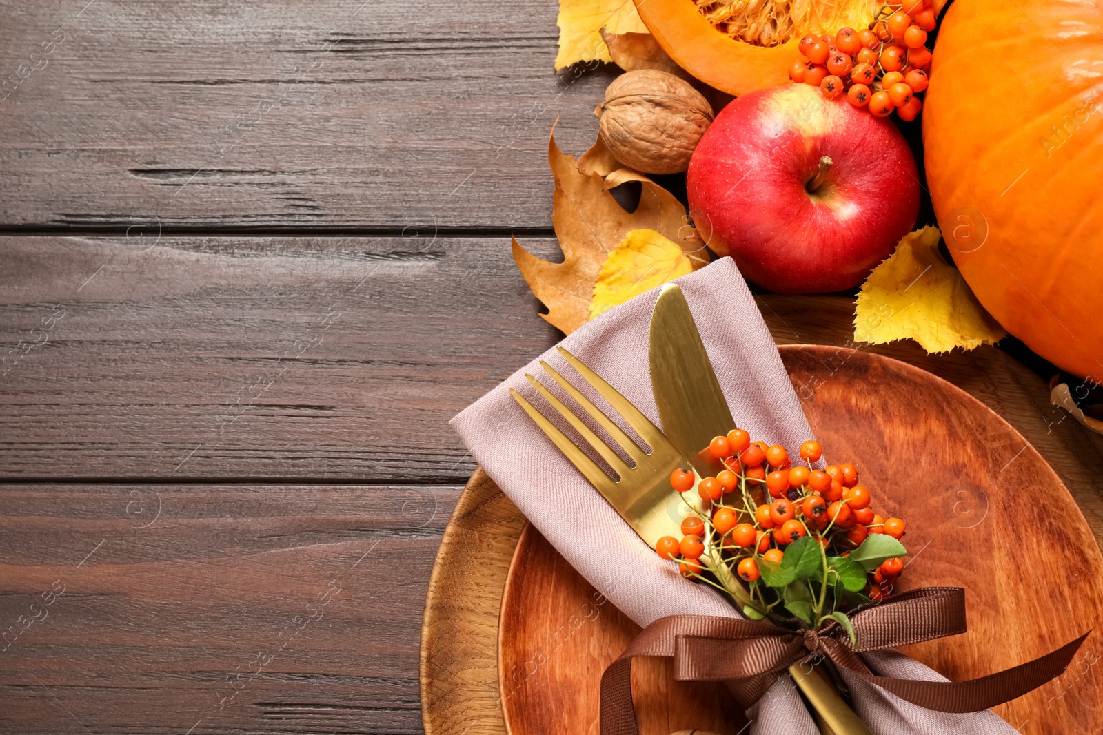 Photo of Flat lay composition with table setting, berries and autumn leaves on wooden background, space for text. Thanksgiving Day
